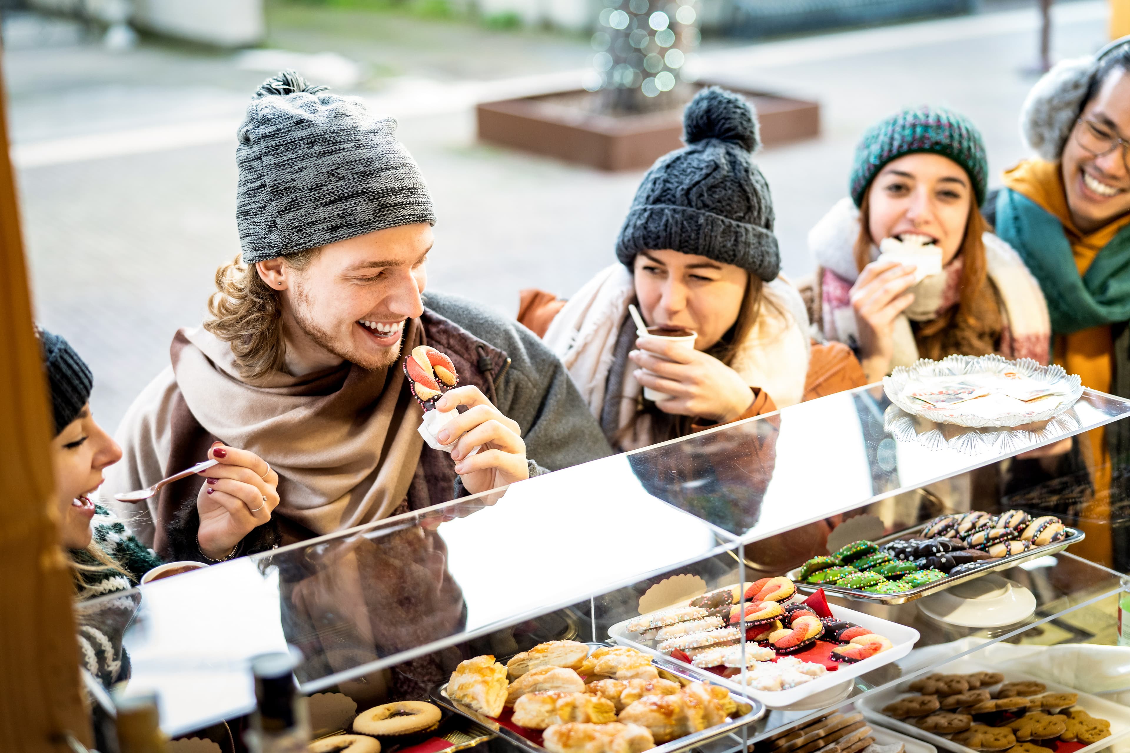 Convives souriants devant un stand de pâtisseries et de boissons